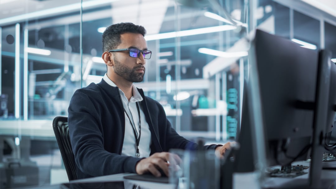 Guy sitting at desk on latpop